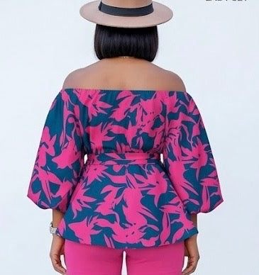 The Bloom Two-Piece Set is confidence in print form. A vibrant hot pink floral pattern bursts across a deep navy off-shoulder peplum top with voluminous balloon sleeves — cinched at the waist with a matching belt tie and paired with solid hot pink biker shorts that complete the look with intention.