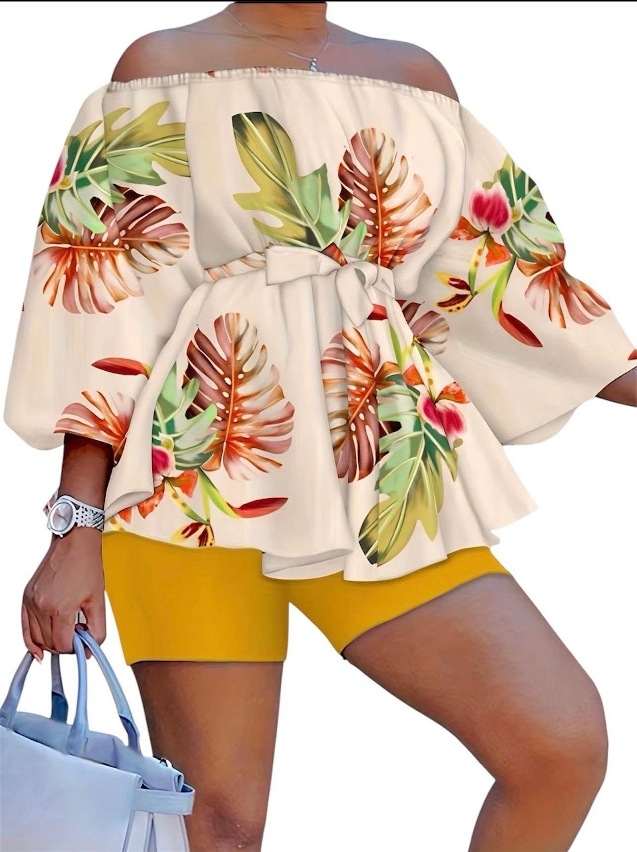 The Golden Hour Two-Piece Set is the calm confidence of a perfect moment — bottled in fabric. A warm champagne base blooms with coral, green, and red tropical florals across an off-shoulder peplum top with soft balloon sleeves — cinched with a matching belt tie and paired with rich gold biker shorts that glow against every skin tone.