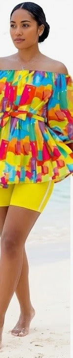 The Palette Two-Piece Set is for the woman who lives in full color. A vibrant abstract paint-block print in yellow, orange, teal, pink, and purple cascades across an off-shoulder peplum top with voluminous balloon sleeves — cinched at the waist with a matching belt tie and anchored by bold yellow biker shorts that pull the whole canvas together.