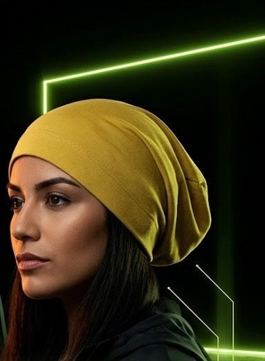 The Satin Crown Beanie in Goldenrod doesn’t blend in — and that’s the point. A rich mustard yellow exterior in a 90% cotton and 10% spandex blend wraps around a smooth satin lining that keeps your edges intact and your style sharp.
