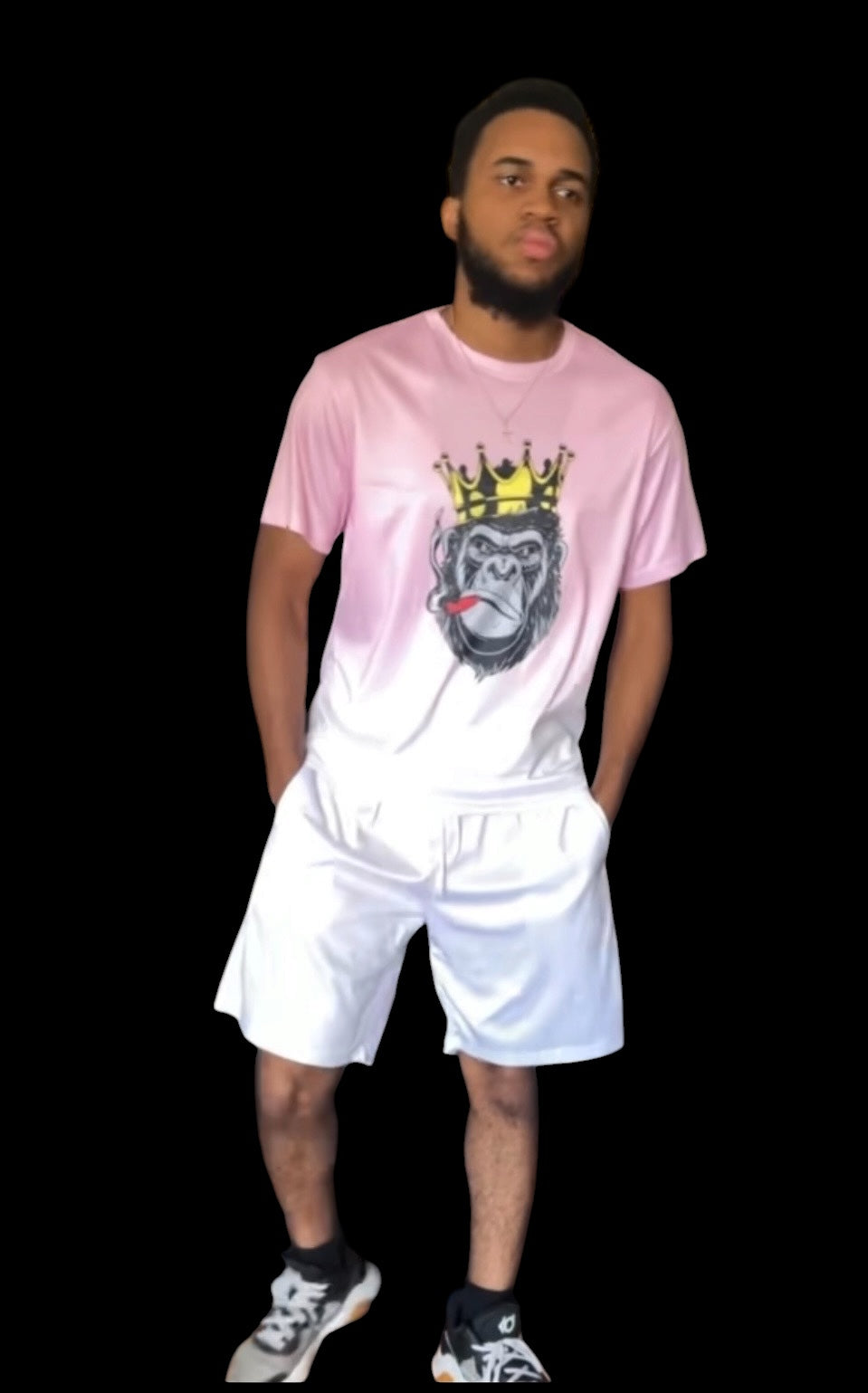A soft pink gradient fades to white across an oversized crewneck tee anchored by a bold crowned gorilla graphic — street art energy meets resort ease. Paired with clean white shorts that let the top lead without competition.

