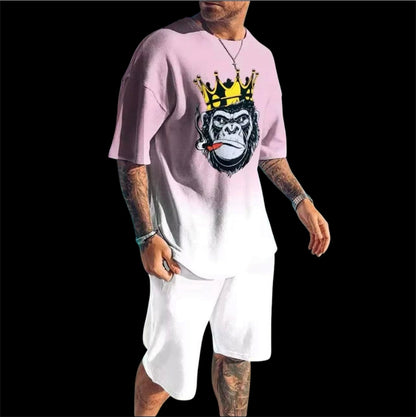 A soft pink gradient fades to white across an oversized crewneck tee anchored by a bold crowned gorilla graphic — street art energy meets resort ease. Paired with clean white shorts that let the top lead without competition.
