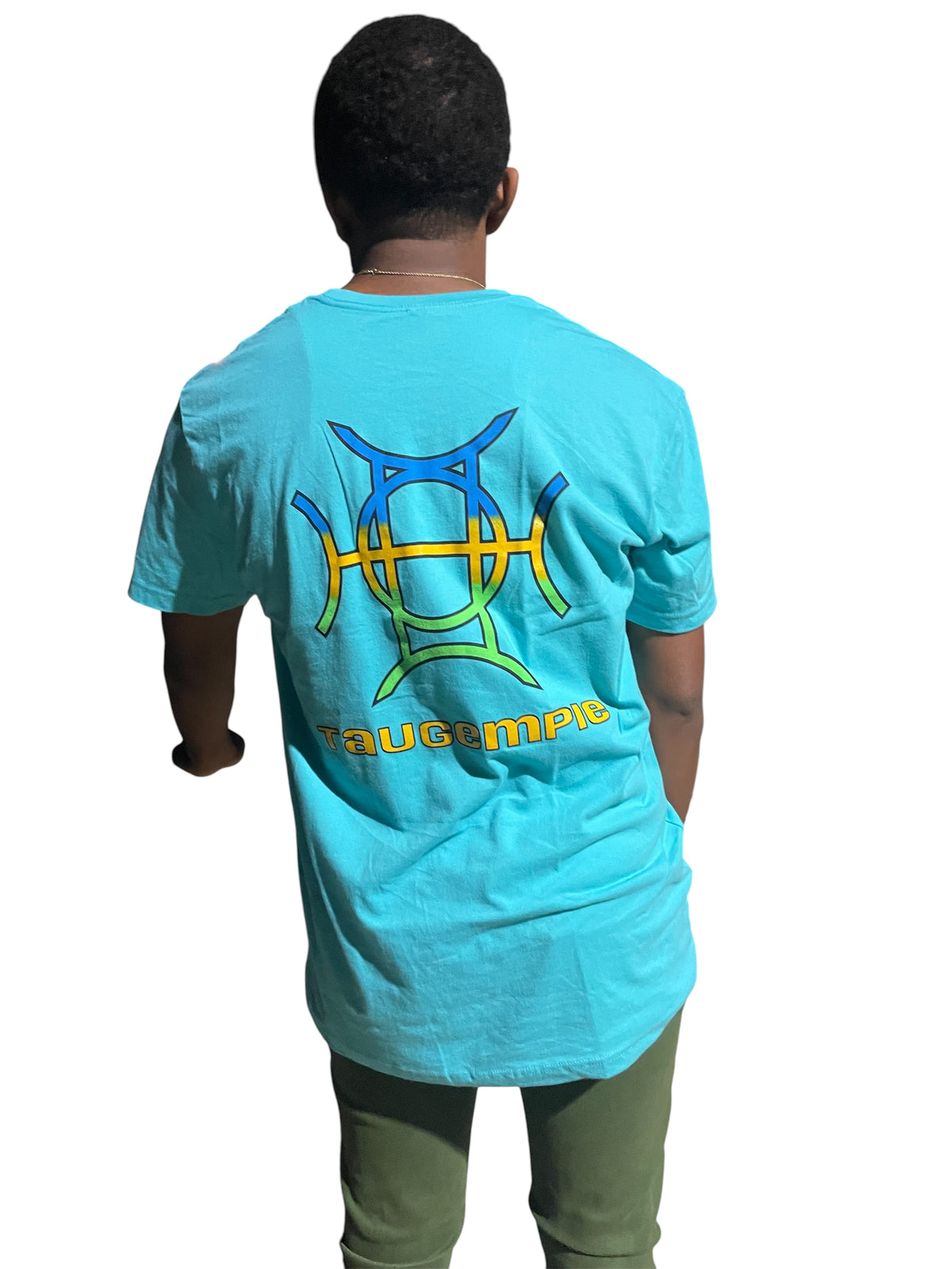 The Mark Crew in Blue doesn’t blend into the background — it owns it. A striking turquoise 100% cotton crewneck carries the TAUGEMPIE crest mark on the left chest and the full signature logo graphic across the back in vivid blue, green, and gold.
