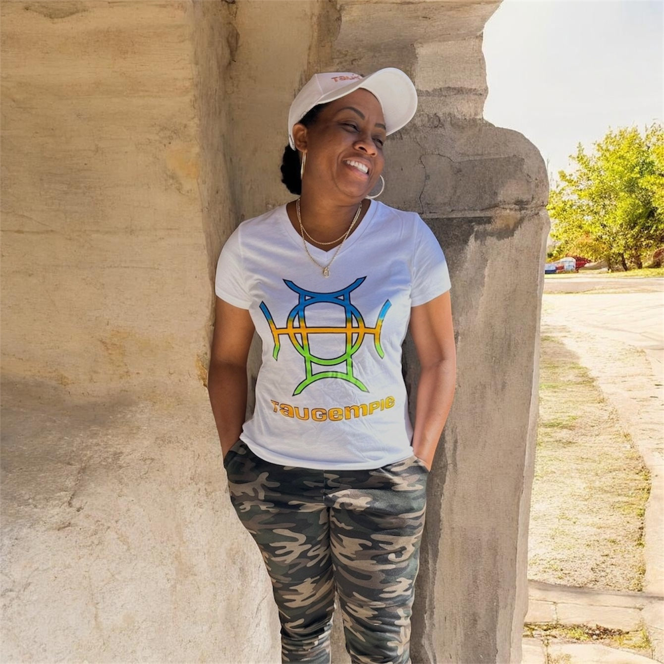 White is the ultimate foundation — and The Mark Tee in White builds on it with intention. A crisp 100% cotton v-neck in clean white carries the TAUGEMPIE signature logo graphic in blue, green, and gold across the chest — bold enough to lead, versatile enough to go anywhere.