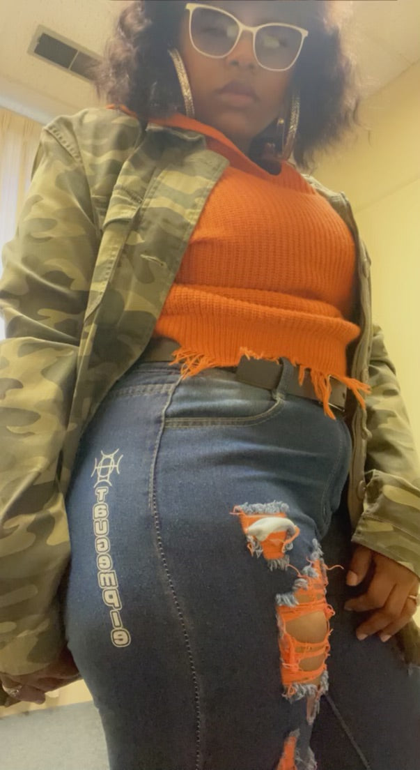 The Voltage Shredded Jean in Orange doesn’t cool down. Neon orange accent stitching cuts through deliberately shredded distress detail — warm, electric, and built for the woman who brings the heat wherever she goes.